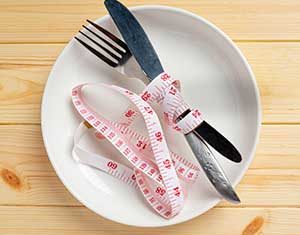 Plate with measuring tape and utensils representing dietary and health considerations for bariatric surgery candidates bariatric surgery packages in Colombia